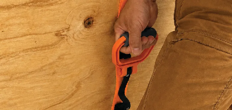 Hand gripping the handle beside a plywood panel